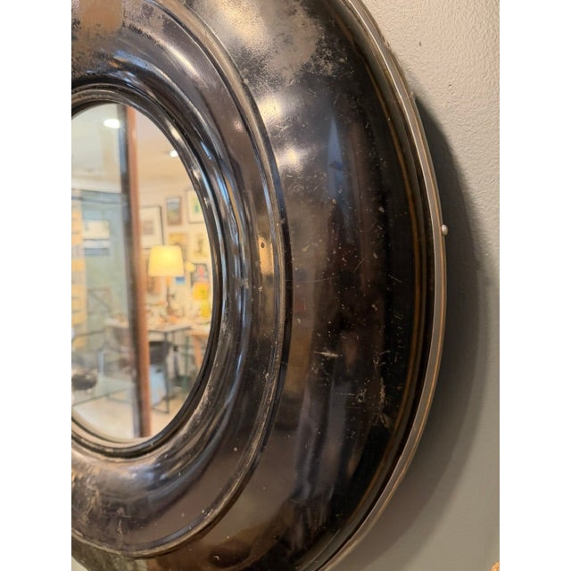 Vintage Chevy tire cover converted to a 30" diameter wall mirror. Chrome accents line the edges.