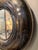 Vintage Chevy tire cover converted to a 30" diameter wall mirror. Chrome accents line the edges.
