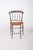 Dark wood dining chair. with a curved back and a backrest made of turned wood that evokes the elegance of 19th century...