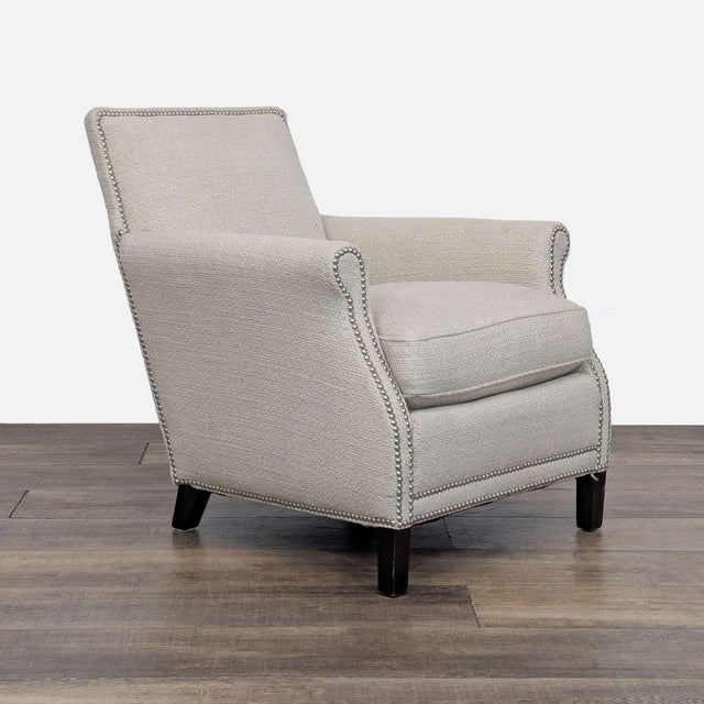 Beige upholstered lounge chair with dark wood legs and nailhead trim. Brand: Lillian August Couture . Original Price:...