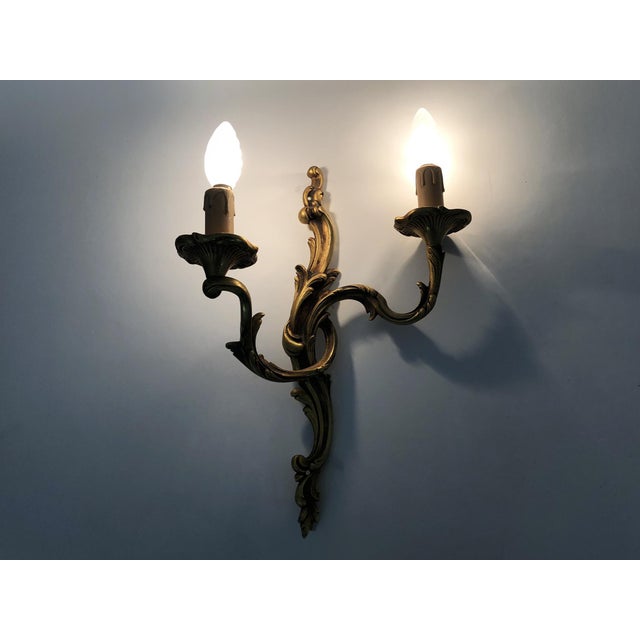 Old pair of bronze double-light wall sconces, acanthus leaf. 50s Large pair of bronze wall sconces, the two sconces are...