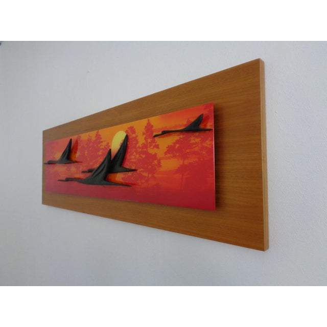 Large, decorative, three-dimensional wall hanging of four flying cranes at sunset. Cranes made of black lacquered wood....