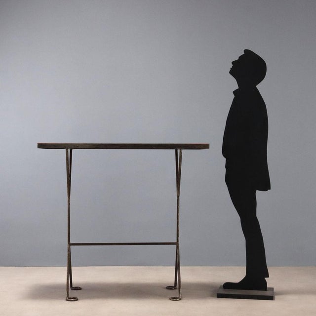 This 1990s console table features an iron frame that lends solidity and an industrial feel. The red lacquered wood top...