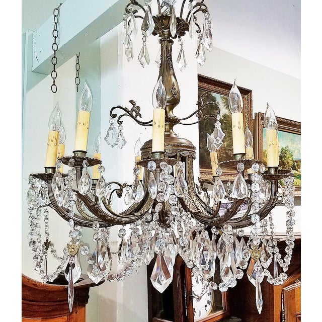 Impressive Bronze and crystal chandelier, mid-century era, 12 lighbulbs refract through 3 levels of 106 crystals including...