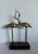 A rare Fredrick Cooper depicting entwined brass cranes on a wooden base.