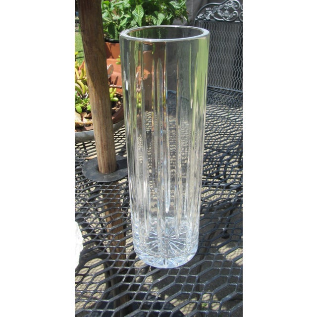 Gorgeous cut glass vase with star burst cut pattern on bottom. Body of vase has long vertical cuts much like the starburst...