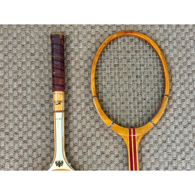 A pair of beautiful midcentury vintage wooden tennis rackets with leather grips. Classic Spalding and Slazenger brands....