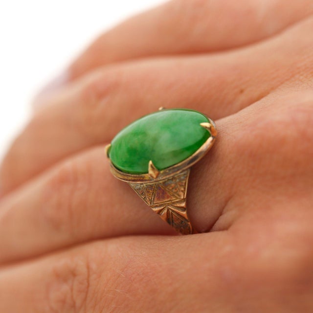 10.01 Carat Natural jadeite jade ring featuring large oval cabochon in 18K yellow gold four-prong setting. Translucent...