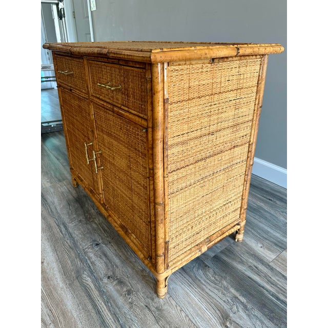 This vintage Italian Bamboo Rattan MCM Woven Wicker Cabinet is a rare find with its original bamboo shaped hardware and...