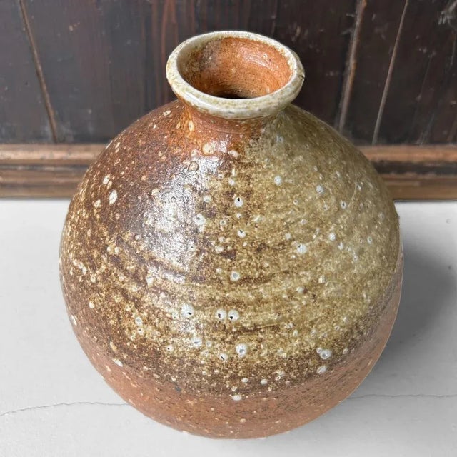 A characterful, hand-formed Shigaraki vase from the 1970s, featuring an organic, rounded shape with a narrow opening –...