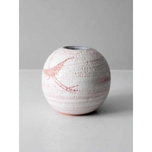 A vintage handmade studio pottery vase with a softly rounded form and beautifully layered glaze in whites with blush and...