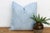 A repeating diamond medallion in soft white ink covers the full face of this pillow, hand block-printed on pale powder-...