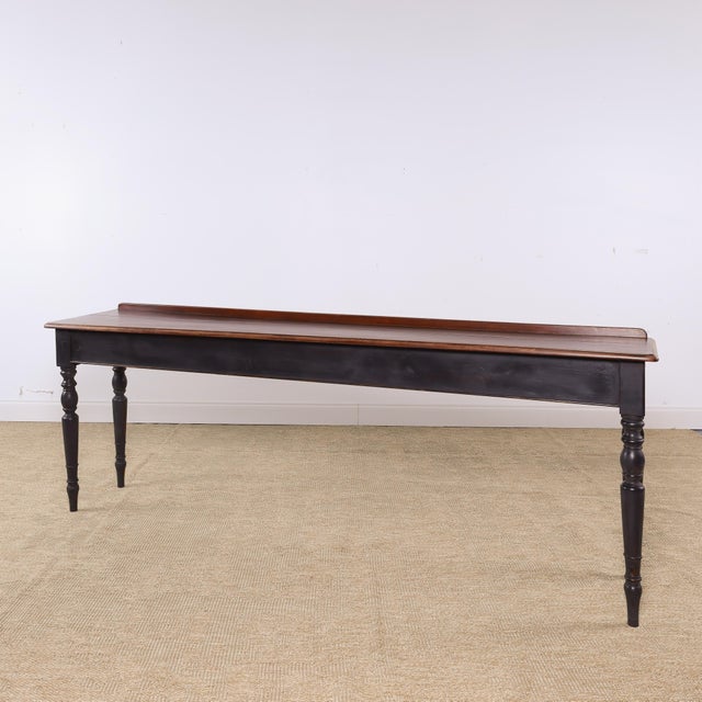 A beautifully proportioned antique mahogany serving table featuring an exceptionally long and narrow profile. The rich...