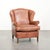 This light cognac-colored cowhide wing armchair has a characterful English look and is finished with matching piping and a...