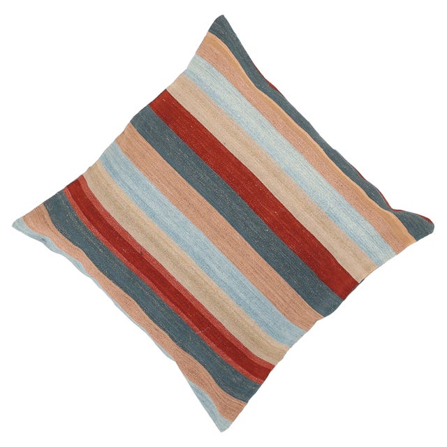 A one-of-a-kind handwoven wool kilim floor pillow featuring a horizontal teal, peach, and red stripe. Fully reversible —...