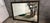Stunning large wall mirror featuring a black frame with elegant gold gilt trim — a leaf/laurel motif along the outer edge...