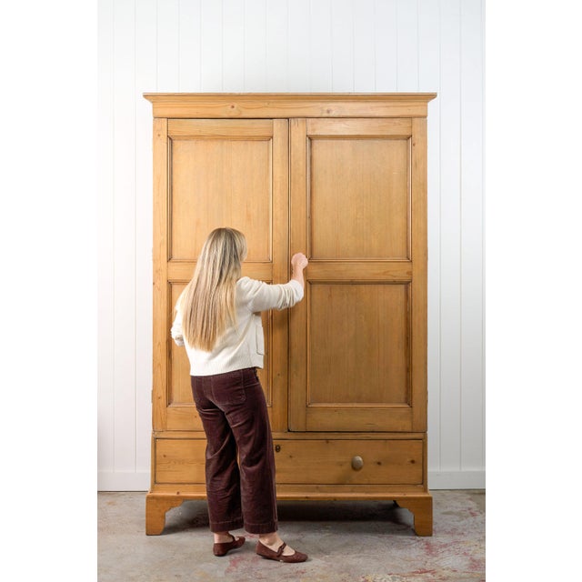 This George III pine knockdown wardrobe is constructed from solid pine and rests on shaped bracket feet. It includes two...