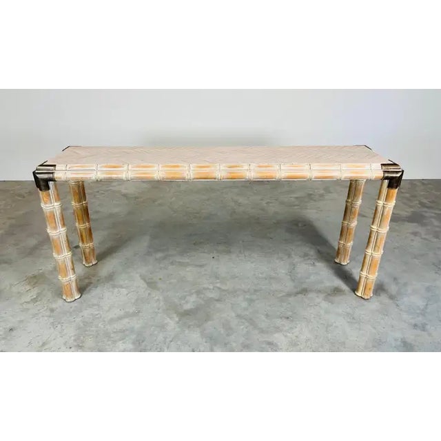 A beautiful faux bamboo console table having cross pattern parquetry inlay top, faux bamboo triple stem legs and brass...