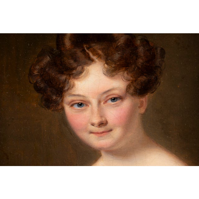 Dimensions without frame: 27 x 21 x 2 cm. This refined oil portrait depicts a young woman presented in a graceful three-...