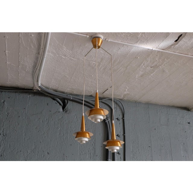 This original-condition three-armed copper pendant light dates to the 1960s. European Plug (up to 250V).The wiring of this...