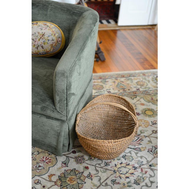 A large early 20th century American splint oak gathering basket with woven twig handle. The charming basket has a tight...