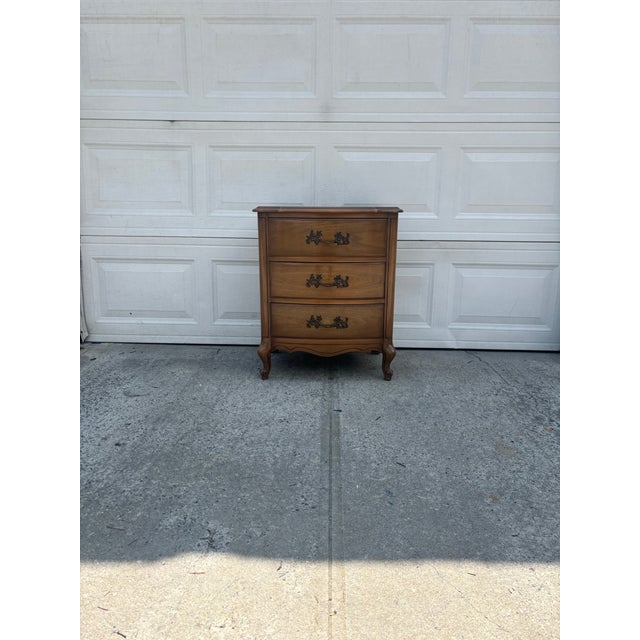 We have a beautiful vintage French Provincial nightstand for sale that features serpentine drawer fronts, cabriole legs,...