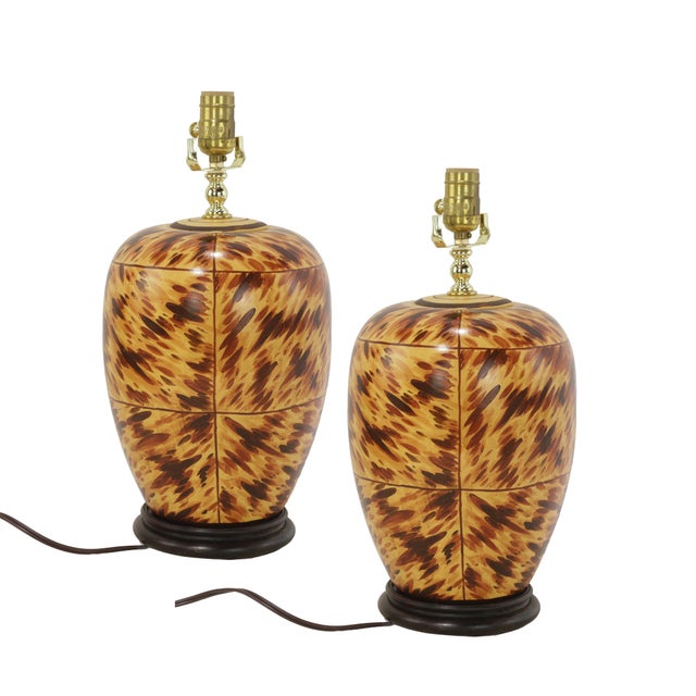 The lamps feature the iconic tortoiseshell texture, showcasing swirling patterns of dark brown, caramel, and beige. The...