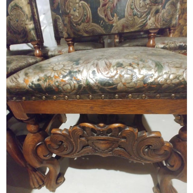 Set of ten incredible Spanish Revival oak dining chairs with original stamped and painted leather upholstery. Circa 1920