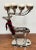 Sleek polished ten point stag deer candelabra on stand. Features large antler rack with 10 candleholders. Tartan scarf is...