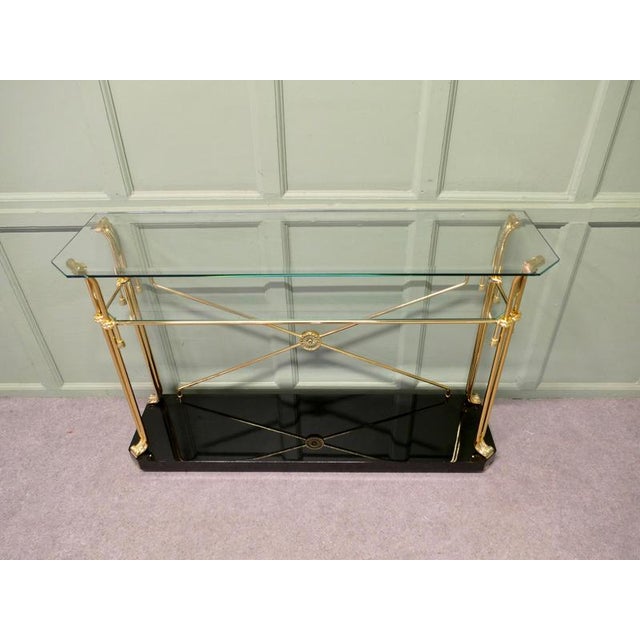 A Stylish Brass and Glass Mid Century Console Table This is a lovely table it is set on a black simulated marble base and...