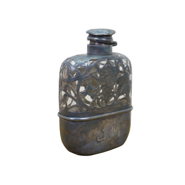 Antique pocket whiskey liquor hip flask featuring intricate sterling silver filigree overlay on a glass body. Features an...