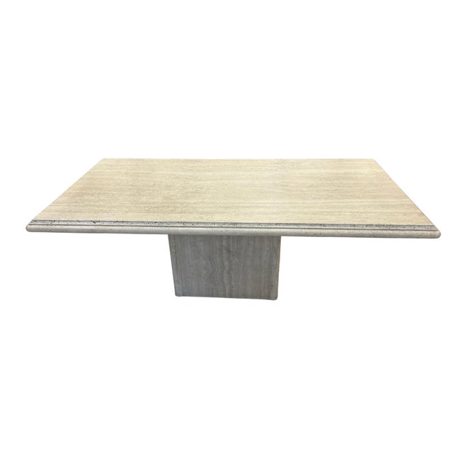The table features a rectangular granite top with a soft, weathered finish in light beige and taupe tones. The surface has...