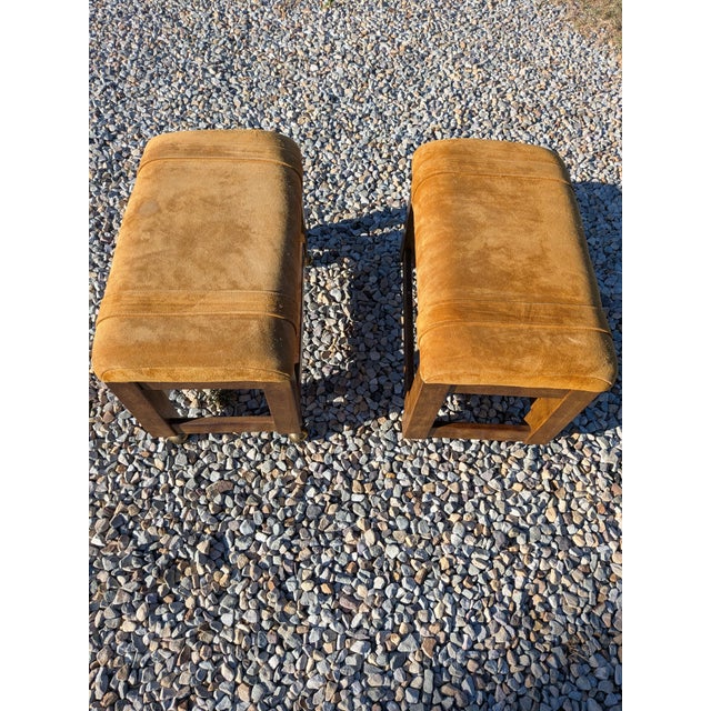A pair of 1970’s Drexel Heritage suede parsons stools/ottomans in a golden tan color. Parson style frame with rolling...