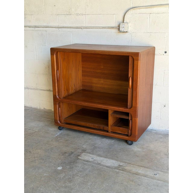 This compact cabinet features smooth tambour doors that disappear seamlessly into a softly rounded frame. Set upon rolling...