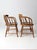 This is a pair of antique captain's chair. The classic wooden barrel style elbow chairs feature turned spindle backs with...