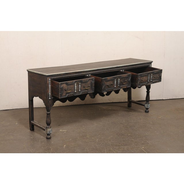 An English Jacobean style oak console table from the turn of the 18th and 19th century. This antique table from England...
