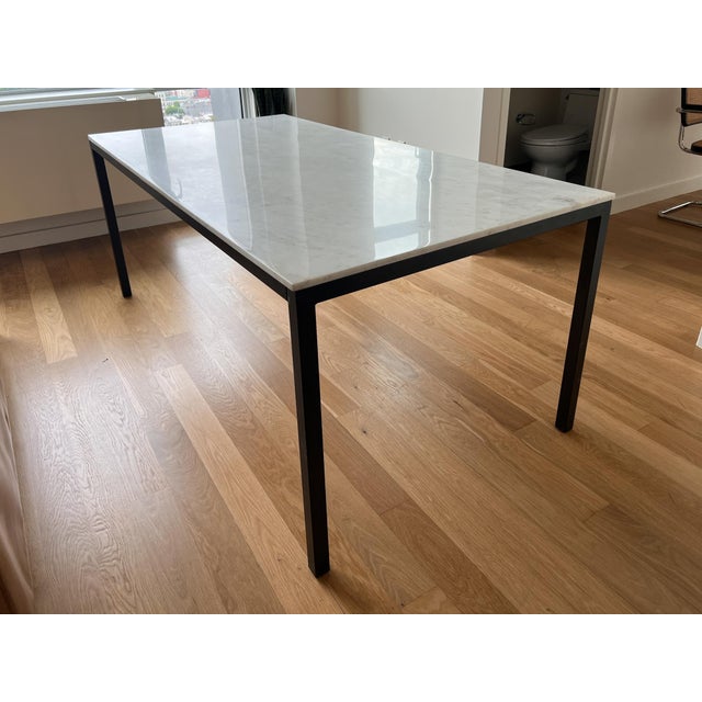 Williams Sonoma Parsons style dining table featuring a polished white marble top and black steel base. The clean...