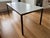 Williams Sonoma Parsons style dining table featuring a polished white marble top and black steel base. The clean...