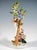 Elaborately crafted porcelain group: a young gardener and three boys harvesting apples, dressed in rural rococo robes with...