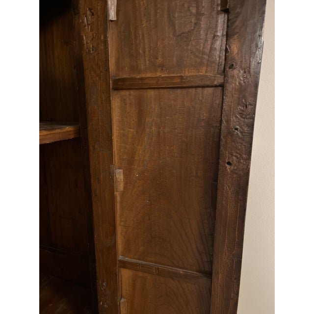 An exceptional 19th-century Chinese Qing Dynasty period tapered wedding cabinet crafted from beautifully grained solid...