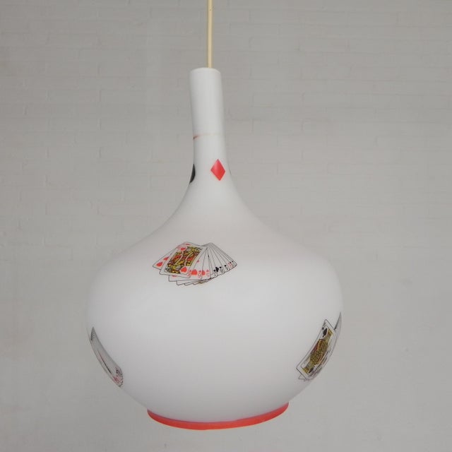 The lamp is made of white opal glass and is bottle-shaped with a narrow neck and a wider base. the shade is printed with...