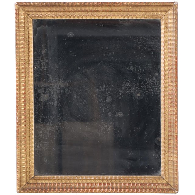 A French mirror featuring a carved frame with classical stepped and molded detailing. This mirror reflects the grandeur...