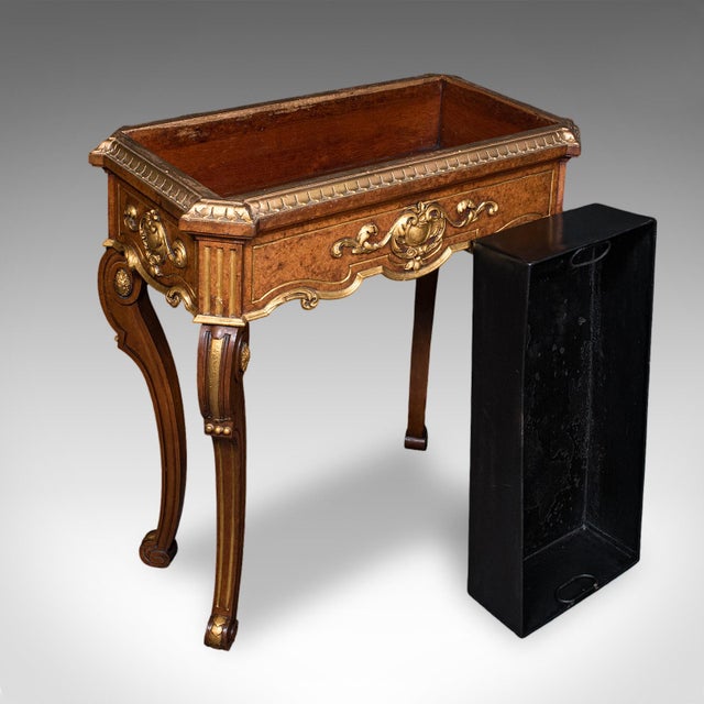 This is an antique jardiniere table. A French, walnut and giltwood planter stand or decanter caddy, dating to the Regency...