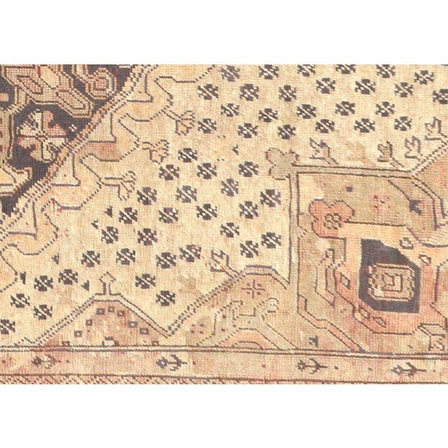 This semi-antique Turkish Oushak rug, measuring 8'3" by 10'9", is handwoven with wool on a wool foundation in Western...