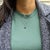 Elegant and captivating, this pendant showcases a 1.82 carat pear shaped Blue Sapphire gemstone encircled by a halo of...