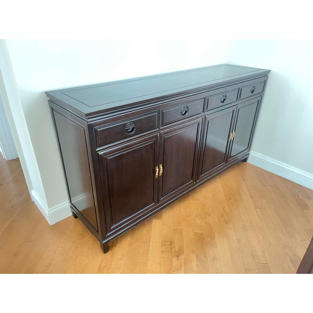 Buffet/ server with made of solid Elmwood with a Rosewood finish. This cabinet offers four carved handle drawers along the...