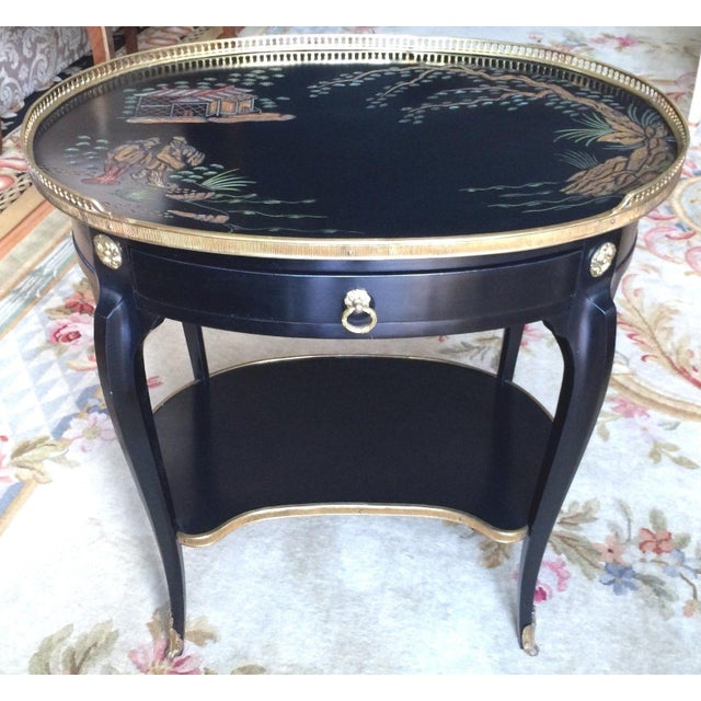 Lovely oval-shaped black Chinoiserie single drawer, table with lower shelf embellished with gilt-bronze ornamentation....
