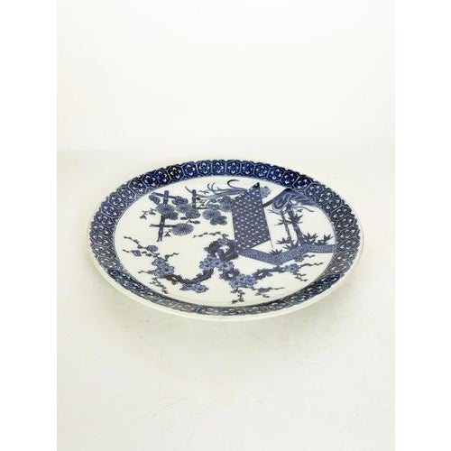 An elegant 19th-century Chinese porcelain plate, decorated in underglaze blue on a white ground. The central design...