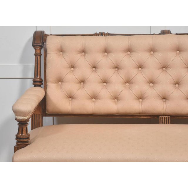 A finely proportioned upholstered settee, featuring a richly figured walnut frame with turned supports and gently scrolled...