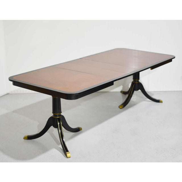 This handsome vintage dining table features a classic silhouette with elegant black banding and a fine gold detail....